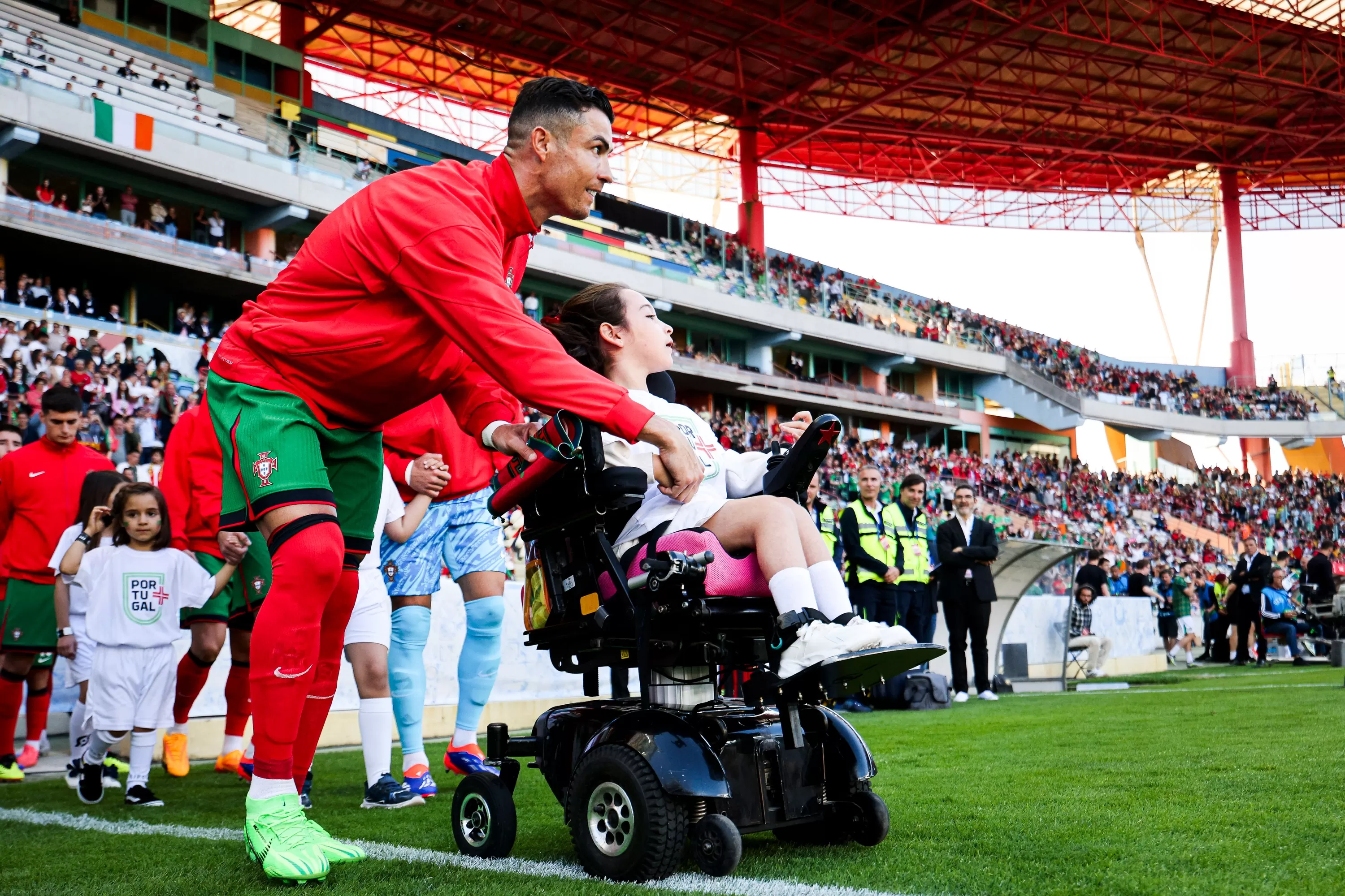 Cristiano Ronaldo junto a una pequeña en silla de ruedas. | Foto: Portugal.
