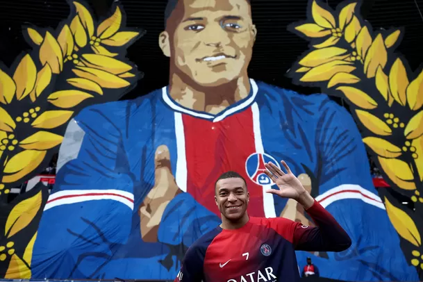 Kylian Mbappé junto al tifo que le preparó la hinchada del PSG. | Foto: AFP.